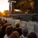 Concierto al atardecer con vallas antiavalancha, pasarela y seguridad detrás de las barreras.